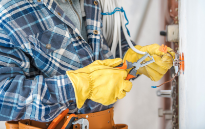 A commercial electrician fixing wiring in a wall